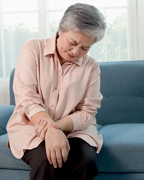 Sitting, holding a knee